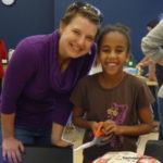 Participants Holly and her daughter Maren wrapping toys for Denver refugee children at an event featuring Project Worthmore